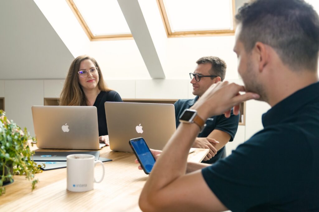 sprejemanje-odlocitev Ekipa sodeluje pri delu za mizo z odprtimi prenosniki.