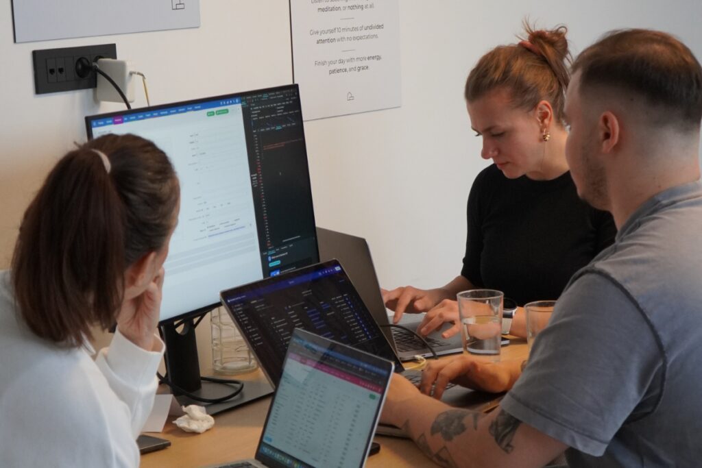 Sodelavci v pisarni skupaj pregledujejo podatke in delajo na računalnikih v okviru uvajanja novih digitalnih orodij.